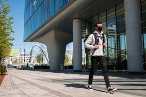 man in gray jacket and black pants standing on gray concrete floor during daytime